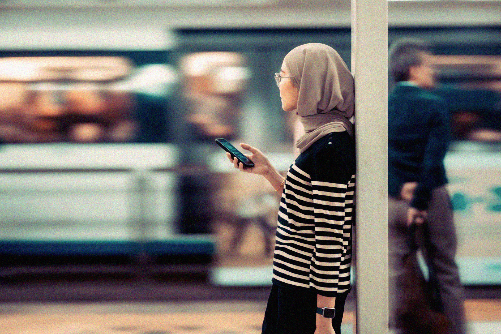 Woman at a train station on her phone