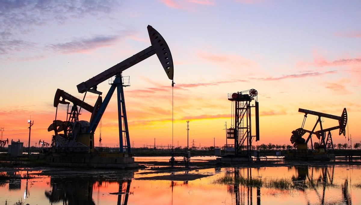 Pump jacks in an oil field at sunset